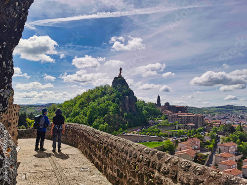 Pilgrims looking at the magnificent view over Le Puy en Velay, departure of the camino de santiago. France. 