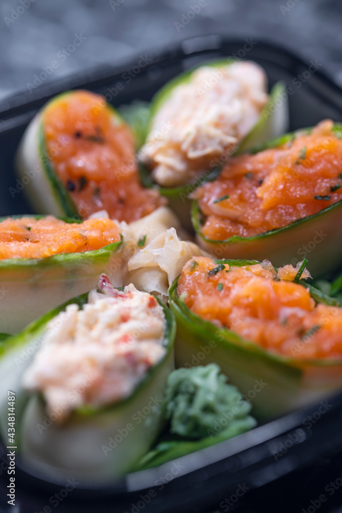 set of sushi rolls with seafood on a black stone background