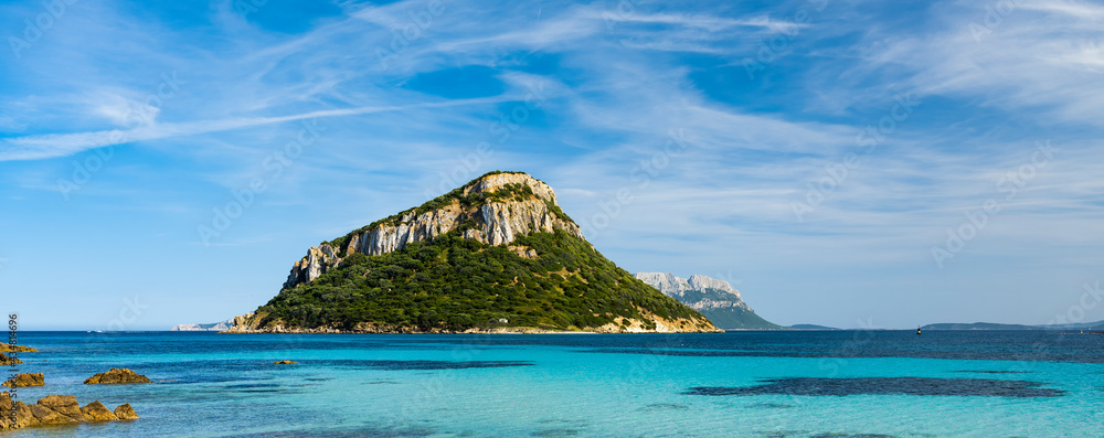 Sunning view of Figarolo island bathed by a turquoise water during a sunny day. Figarolo is an Italian island within the Gulf of Olbia at Golfo Aranci, in north-eastern Sardinia, Italy.