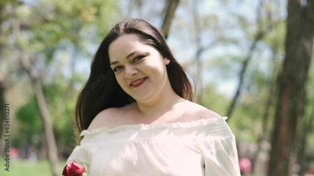 Portrait of attractive brunette woman walking in the park on a sunny day and smiling Portrait of attractive brunette woman walking in the park on a sunny day and smiling