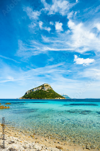 Sunning view of Figarolo island bathed by a turquoise water during a sunny day. Figarolo is an Italian island within the Gulf of Olbia at Golfo Aranci, in north-eastern Sardinia, Italy.