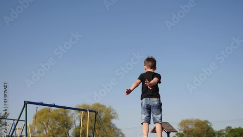 baby boy jumping having fun on a trampoline standing on the street