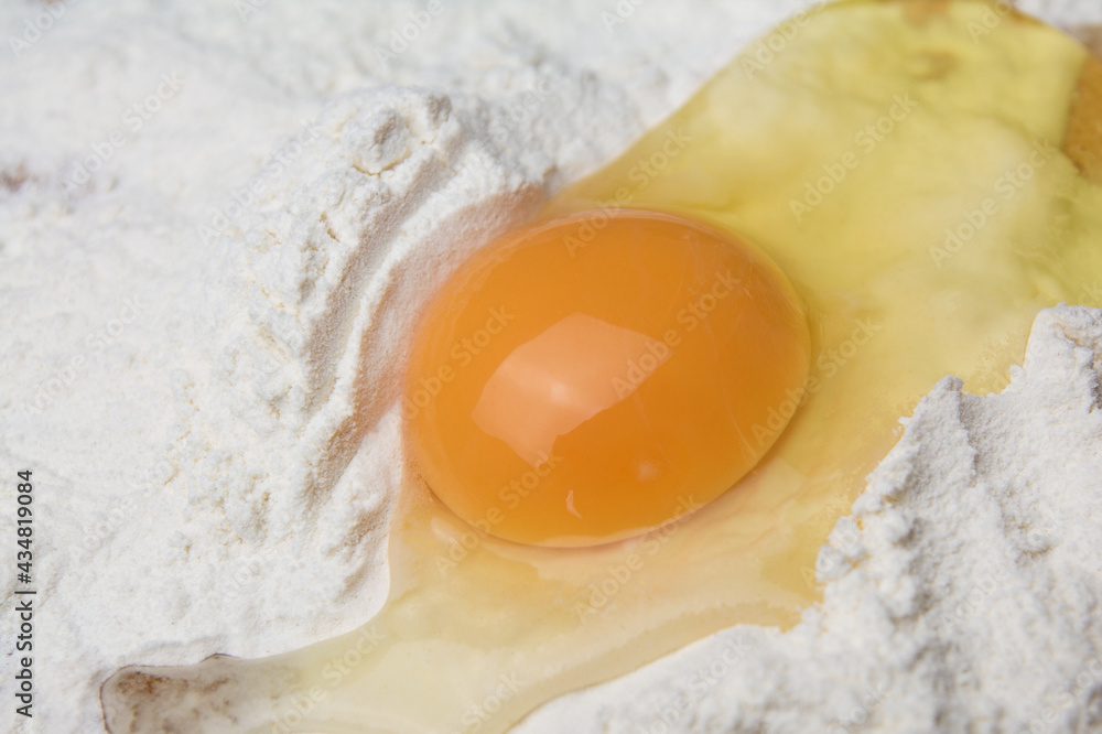 Fresh raw chicken eggs in flour close-up. Mix broken raw eggs and wheat flour, homemade cookies Fresh raw chicken eggs in flour close-up. Mix broken raw eggs and wheat flour, homemade cookies