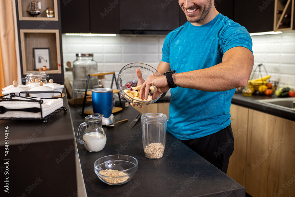 Tasty fruit shake incoming, young man preparing himself a tasty treat in the kitchen Tasty fruit shake incoming, young man preparing himself a tasty treat in the kitchen