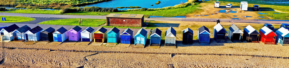 Banner - picturesque aerial image of colorful beach huts by the sea near Southampton in Hampshire, the South of England, taken using a drone.