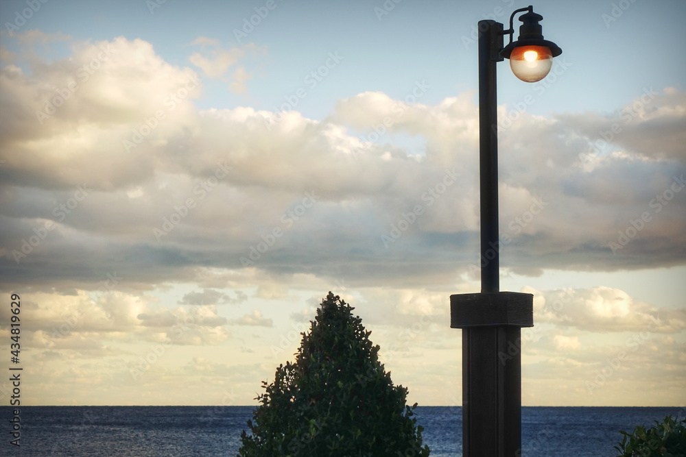 Obraz premium Vintage Single Lamp Post At Seaside Closeup With Round Plafond. Single Lamppost With Cloudy Sky Background At Seaside
