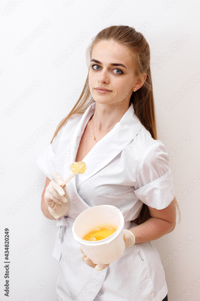 master of depilation with pasta for shugaring on a white background master of depilation with pasta for shugaring on a white background