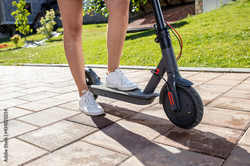 Shot of a young person legs and calves as they stand on the electric kick scooter