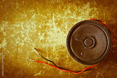 Unplugged vintage sound speaker on a grungy scrapped book cover background photo