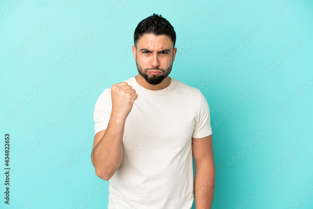 Young arab man isolated on blue background with unhappy expression