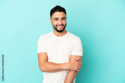 Young arab man isolated on blue background laughing