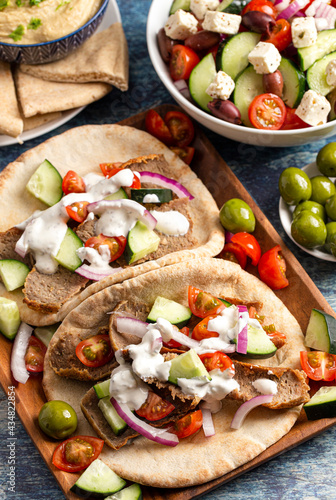 Gyros with Vegetables and White Garlic Sauce on a Rustic Wooden Table