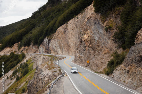 An empty road trip. Traveling through a Patagonia mountain route by car. Peaceful vacation concept. In a cloudy day