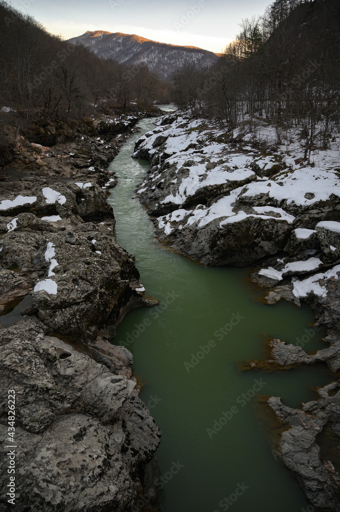 Snowy mountain river on sunset. Green color water Snowy mountain river on sunset. Green color water