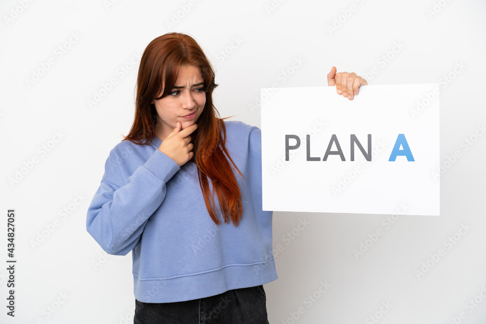 Young redhead woman isolated on white background holding a placard with the message PLAN A and thinking Young redhead woman isolated on white background holding a placard with the message PLAN A and thinking