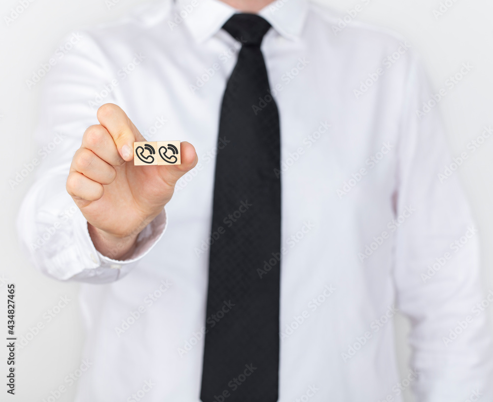 Phone icon background on wooden blocks with a businessman. Connection, communication, assistance and service support in business concept. Phone icon background on wooden blocks with a businessman. Connection, communication, assistance and service support in business concept.