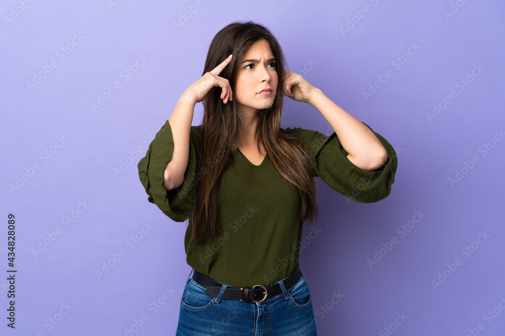 Teenager Brazilian girl over isolated purple background having doubts and thinking Teenager Brazilian girl over isolated purple background having doubts and thinking
