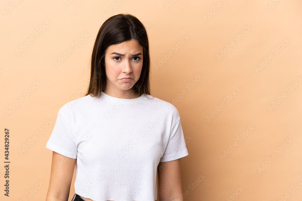 Teenager Brazilian girl over isolated background with sad expression Teenager Brazilian girl over isolated background with sad expression