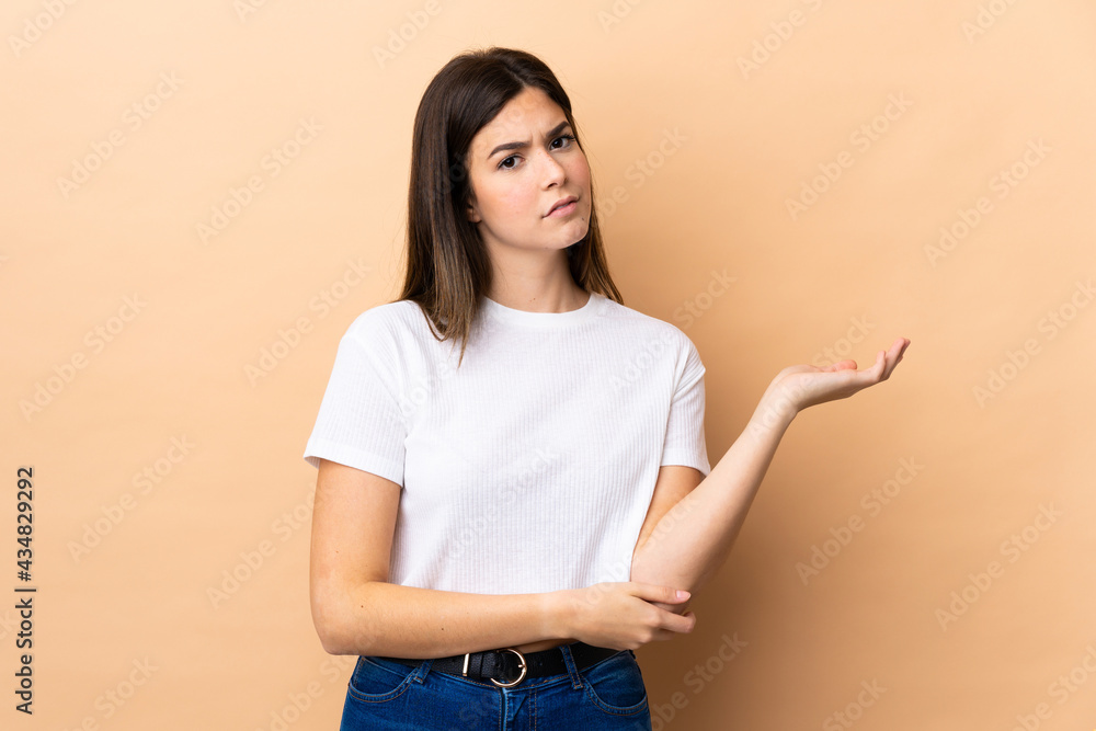Teenager Brazilian girl over isolated background having doubts Teenager Brazilian girl over isolated background having doubts