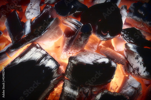 Barbecue Crill Pit With Glowing And Flaming Hot Charcoal Briquettes Background, Close-Up. Charcoal Glow In Fireplace. photo