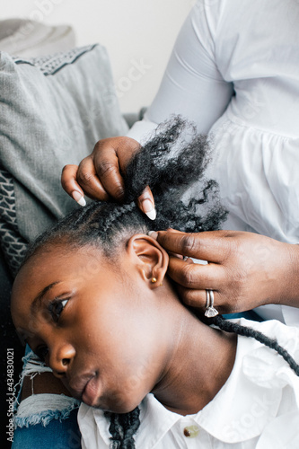Картината върху платно Close up of woman braiding her daughter's hair