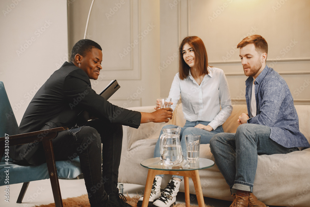 Fototapeta premium Male psychoterapist giving water to man on therapy session