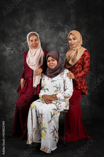 Three modeling of Asian Muslim women when posing in the studio with a textured black oil painting texture.