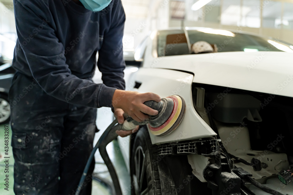 Fototapeta premium Young Spanish man sanding customer's car for money. Madrid