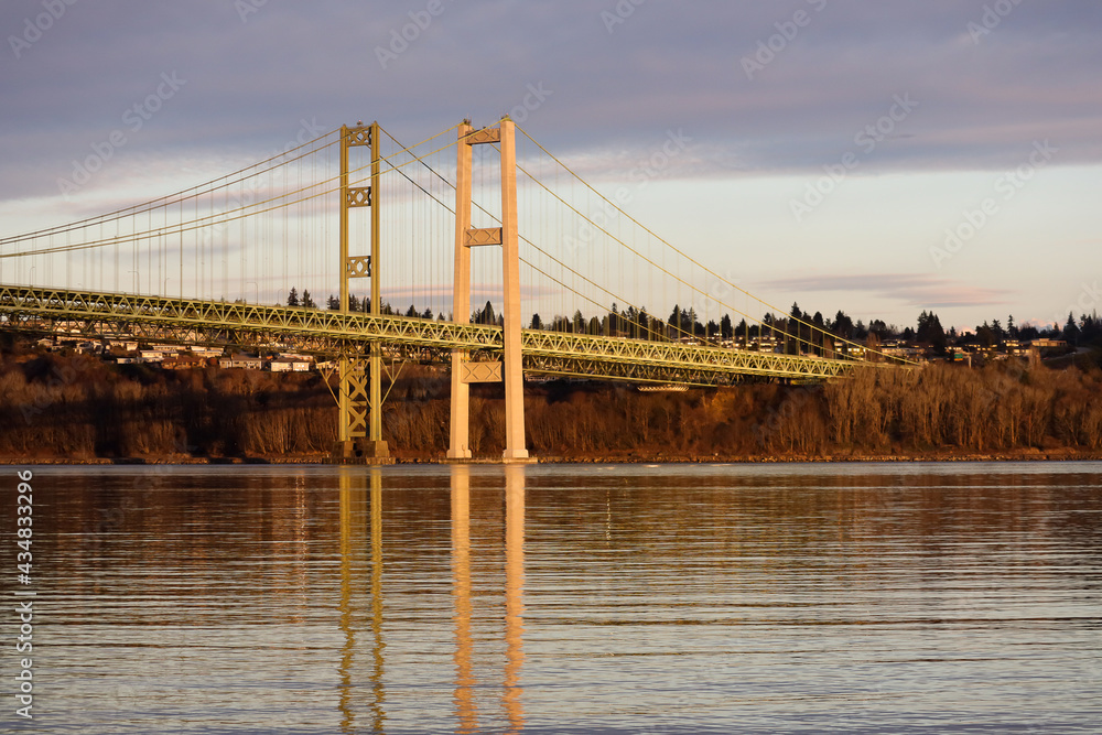 Tacoma Narrows Bridge in sunset lighting under clouds