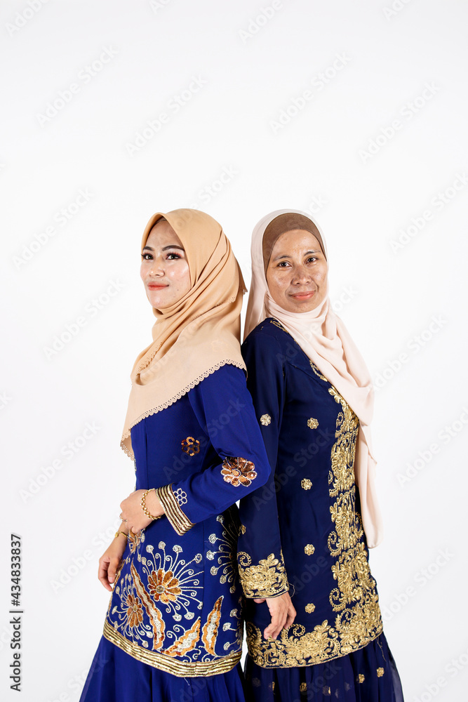 Studio portrait of mother and daughter dressed for an event. Fashion for dinner, event and feast day. Studio shot with white background. Studio portrait of mother and daughter dressed for an event. Fashion for dinner, event and feast day. Studio shot with white background.
