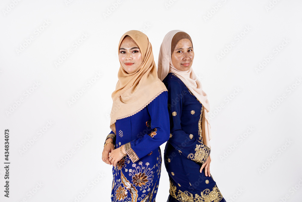 Studio portrait of mother and daughter dressed for an event. Fashion for dinner, event and feast day. Studio shot with white background. Studio portrait of mother and daughter dressed for an event. Fashion for dinner, event and feast day. Studio shot with white background.
