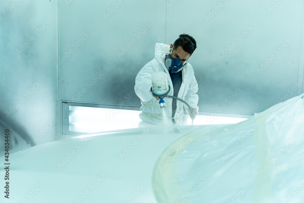 Hardworking Spanish guy paints pearl white car in the box, Madrid
