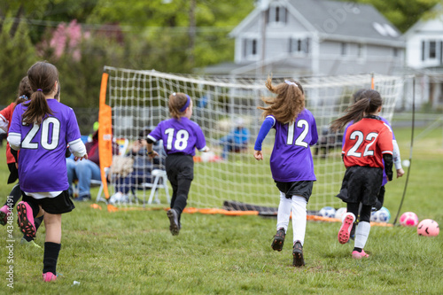 Girls running playing soccer