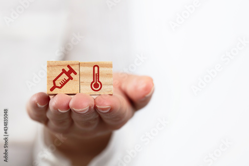 Wood block with Medicine and Healthcare on wood blocks concept. high fever and vaccination symbol.

