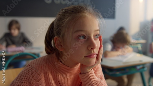 Girl schooling in classroom. Portrait of female student boring during lesson