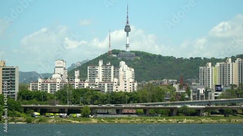 Patrol vessel on Hanriver, Namsan Seoul N tower and traffic on highway in Yongsan district, South Korea photo