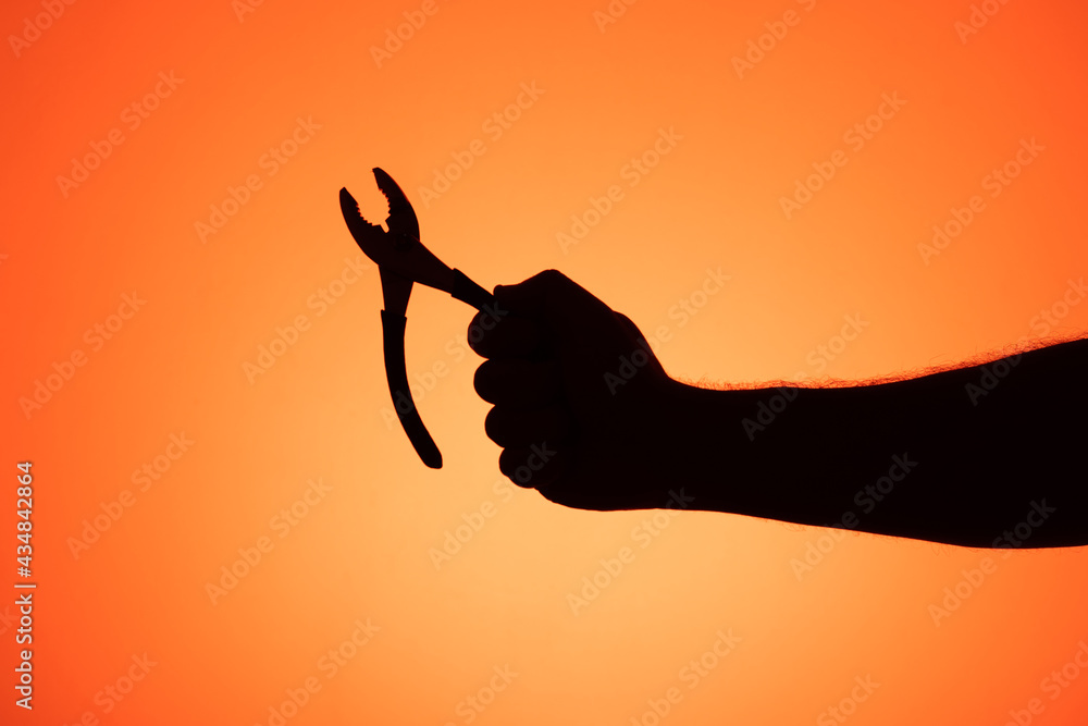 Hand holding pliers. Silhouette photos