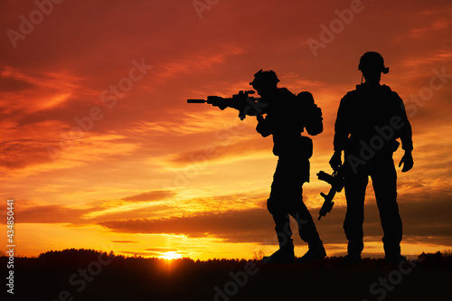 Silhouette of a soldiers against the sunrise. Concept - protection, patriotism, honor.