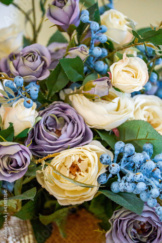 A bouquet of artificial flowers, Morandi yellow and purple roses, blueberries