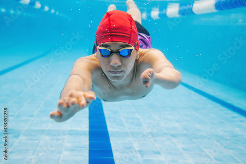 Foto portrait of paralympic Swimmer young latin man Underwater Training In Pool with