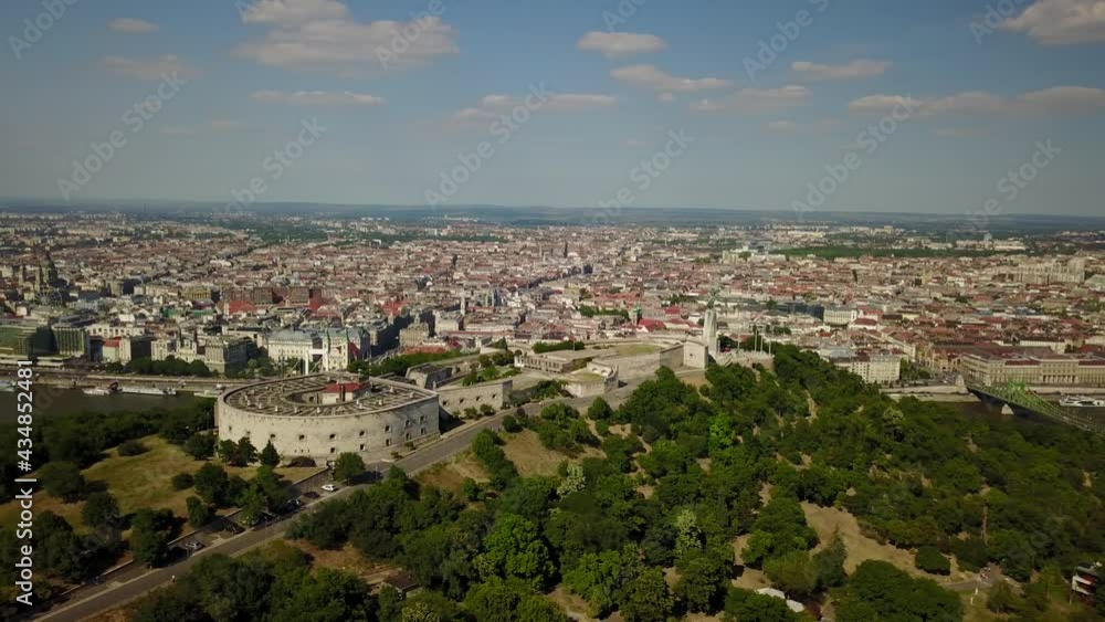 Cinematic aerial panning drone shot of Castle Hill, Buda Castle viewed from Gellért Hill and the Citadella fortress with the Danube river, bridges and Pest in the backdrop in Budapest, Hungary Cinematic aerial panning drone shot of Castle Hill, Buda Castle viewed from Gellért Hill and the Citadella fortress with the Danube river, bridges and Pest in the backdrop in Budapest, Hungary