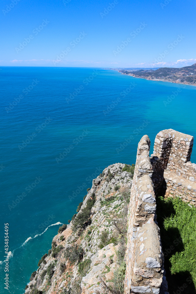 battlements of medieval Alanya fortress in Turkey with azure mediterranean sea on the background