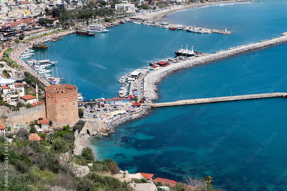 view to famous ancient landmark Red tower (Kizil Kule) in Turkey with Alanya bay and port marina