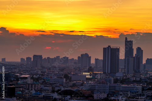 The blurred abstract background of the morning sun exposure to the tiny dust particles that surround the tall buildings in the capital, the long-term health issue of pollution © bangprik