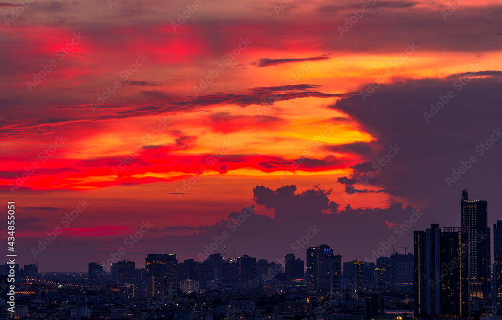 Fototapeta premium Panorama background of city views, with colorful twilight sky, high-rise buildings (condominiums, offices, expressways) and blurred lights from roads and traffic.