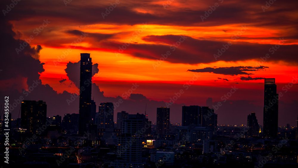 Fototapeta premium Panorama background of city views, with colorful twilight sky, high-rise buildings (condominiums, offices, expressways) and blurred lights from roads and traffic.