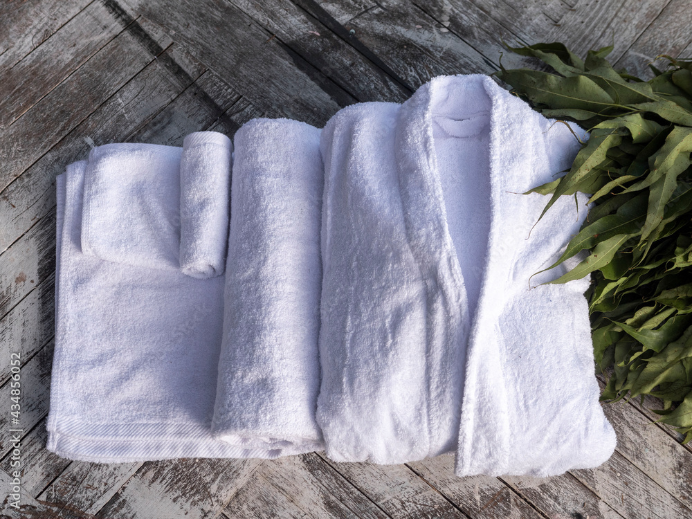 Terry bathrobe and towel on a wooden background. Spa, sauna, Russian bath. Terry bathrobe and towel on a wooden background. Spa, sauna, Russian bath.