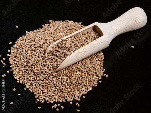 Fotografi scoop on unhulled barnyard millet seeds on black