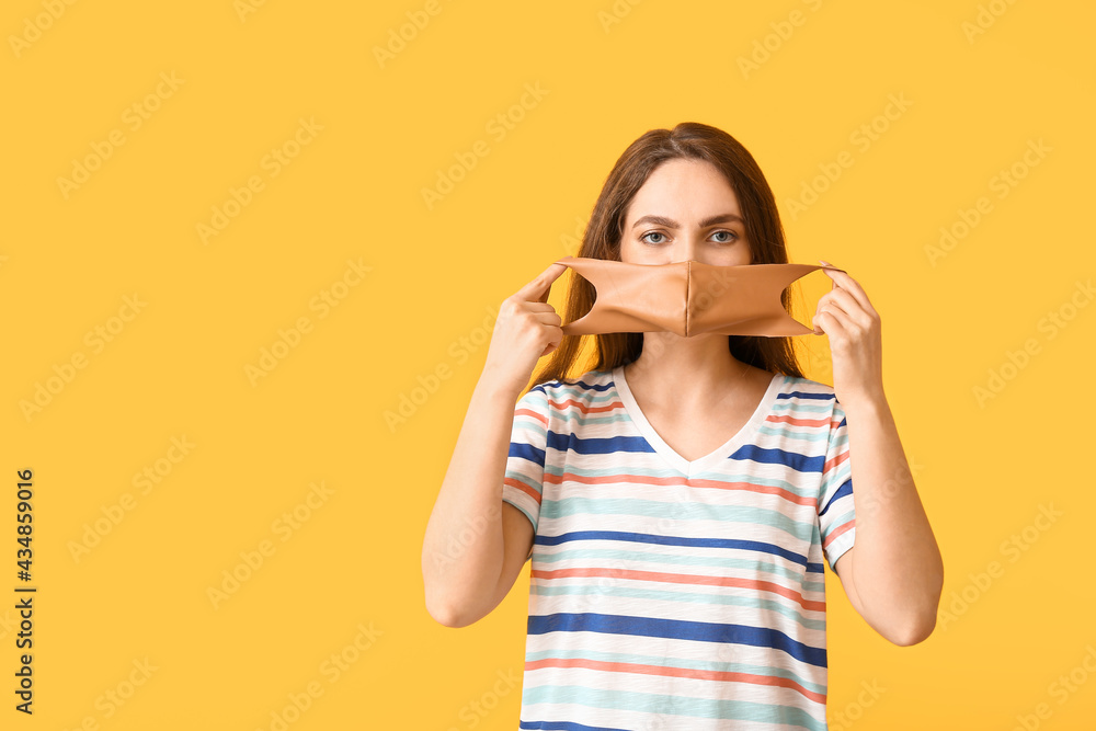 Young woman wearing medical mask on color background Young woman wearing medical mask on color background