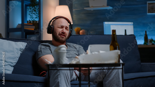 Konstfotografi Hopeless depressed man listening sad music at headphones, sitting alone frustrat